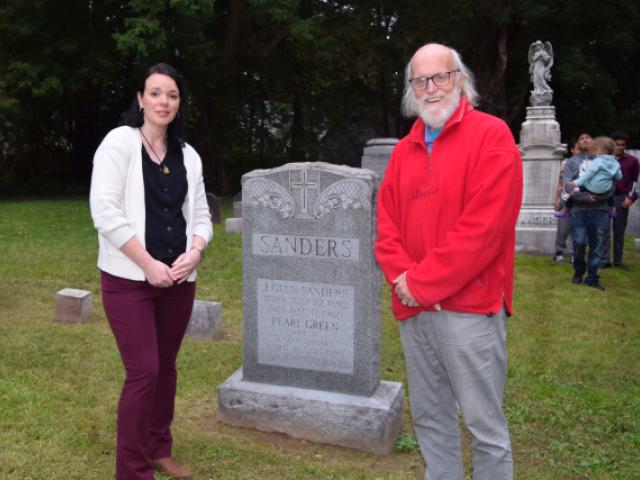 Town of Glenville Historian Emily Spinner and Schenectady County Historian Bill Buell stand beside the J. Glen Sanders headstone at the Glen Sanders Cemetery in Scotia for a recent DAR event.