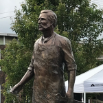 Photo of a bronze statue depicting George Westinghouse Jr. wearing an industrial apron hold a wrench. The statue is located in the City of Schenectady.  
